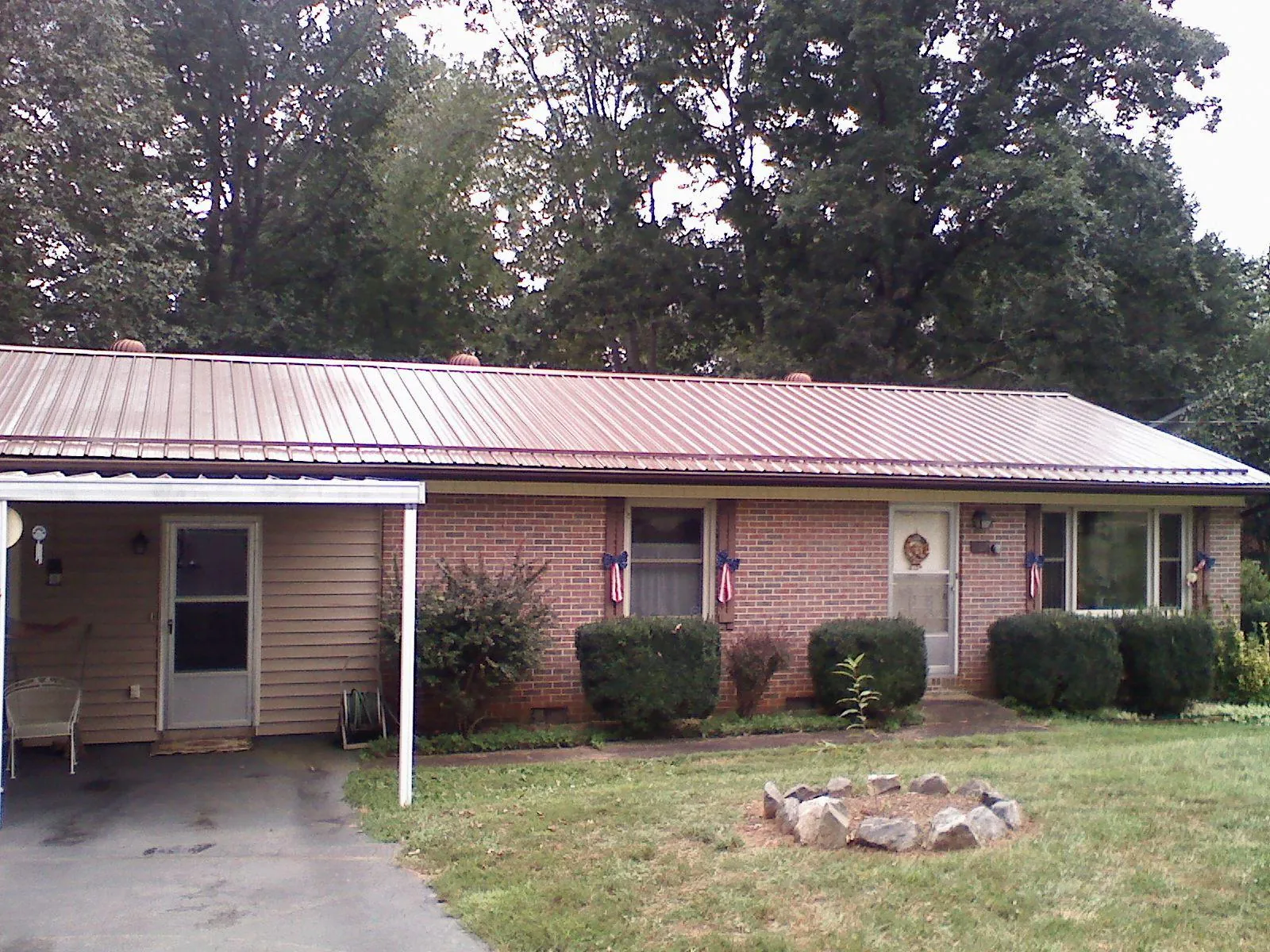 Bronze metal roof and carport on a brick ranch home — Roof Repair work by our crew in Sanibel